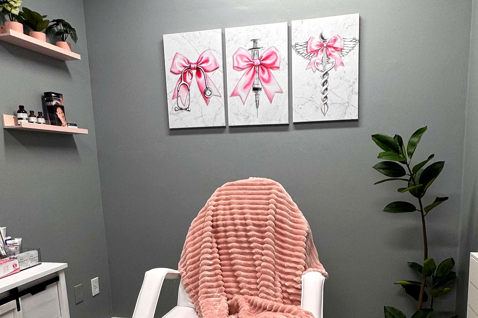 The treatment chair under three pink bow canvases