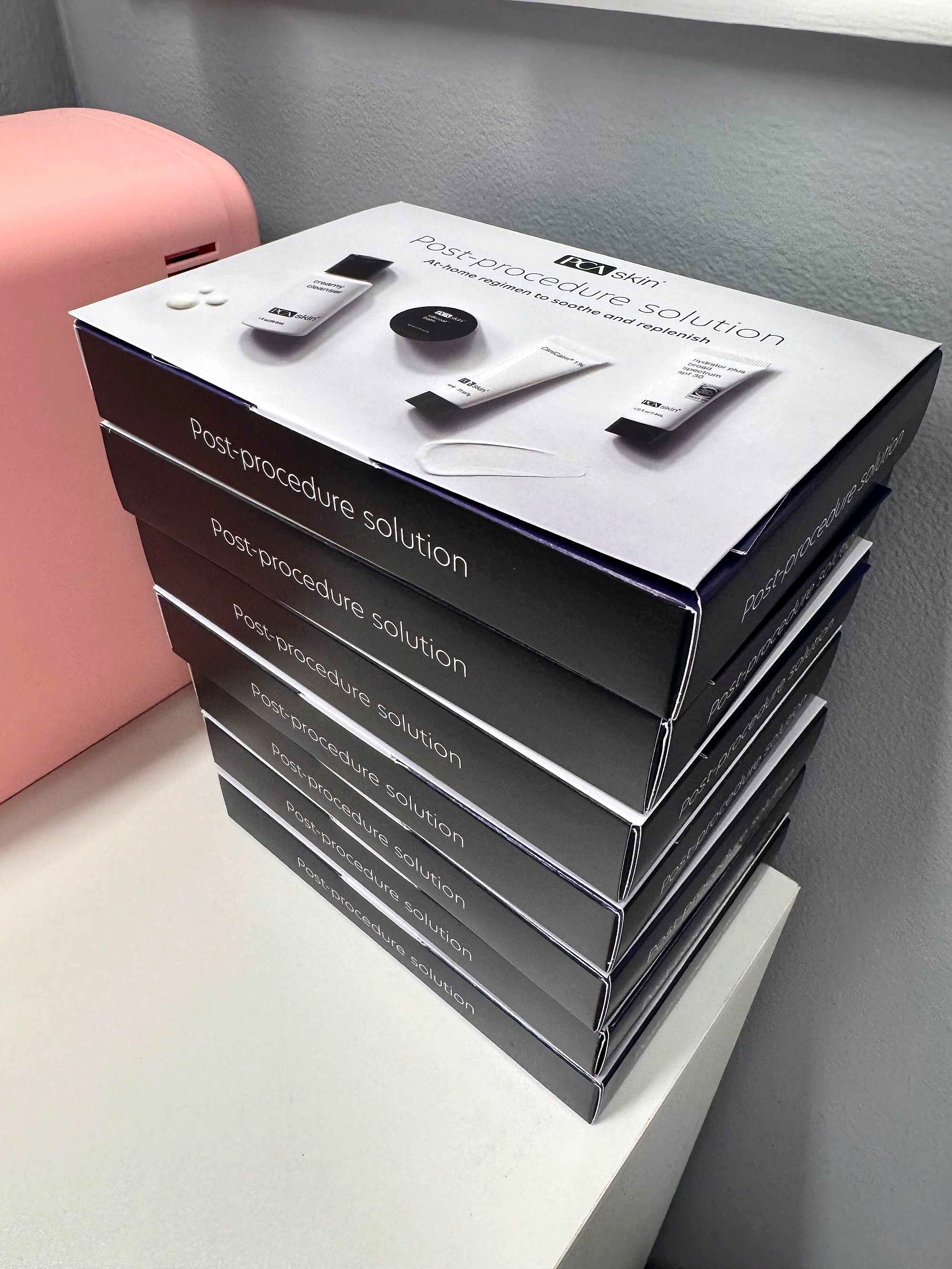 A stack of VI Peel post-procedure kits by the blush mini fridge