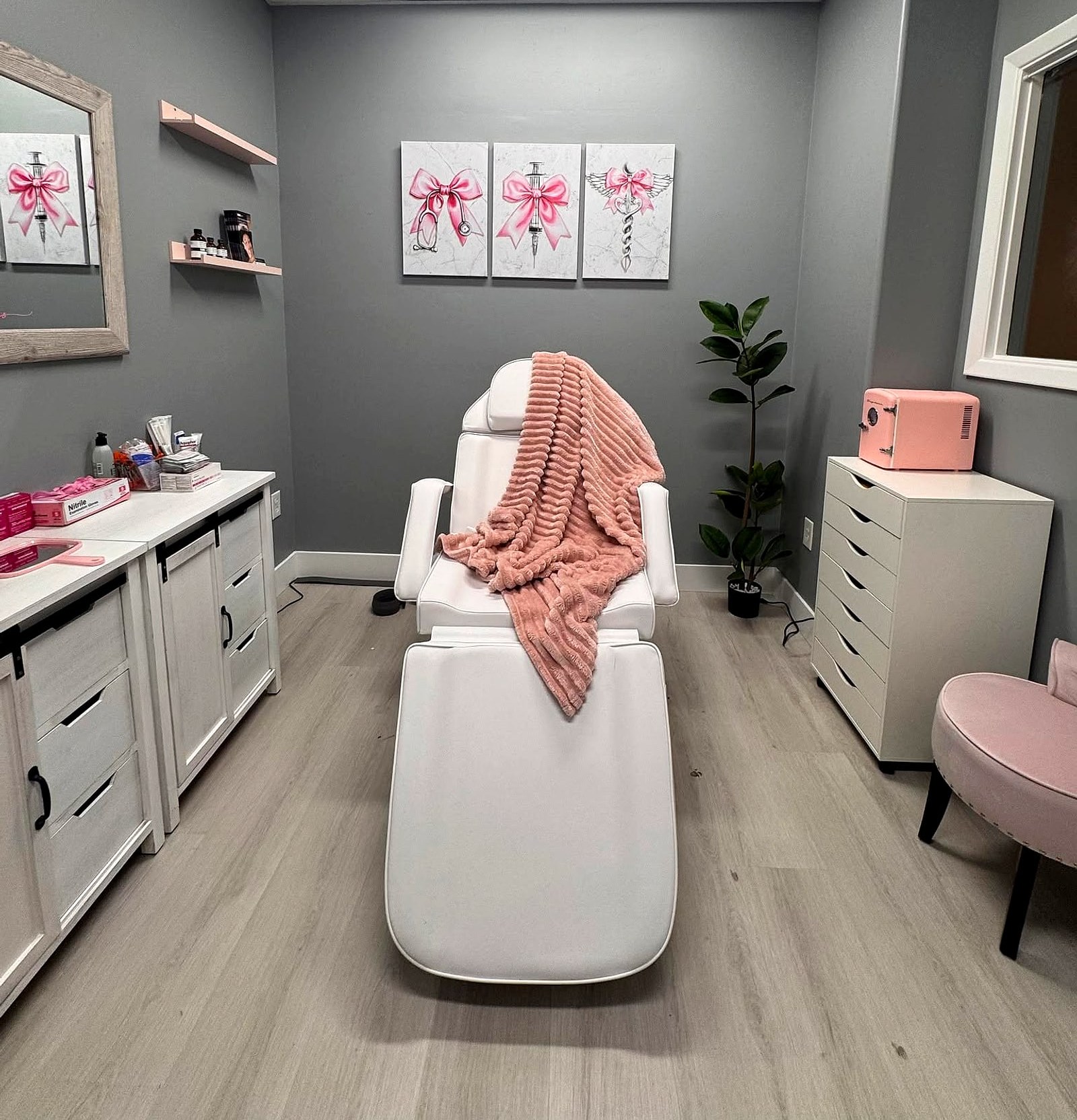Kristine’s suite: a white treatment chair with a blush throw under pink bow canvases